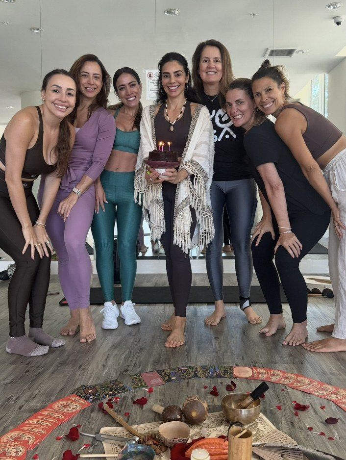 Participantes reunidas em volta de um altar com tigelas, flores e pétalas